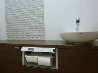 キャパシアをトイレの奥行に合わせて設置。丸形手洗器と壁のアクセントのエコカラットで質感がアップ。